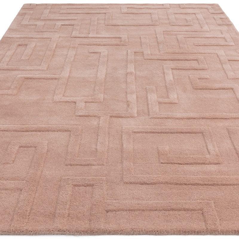 Beige geometric pattern rug with raised texture, shown from a low angle on a flat surface