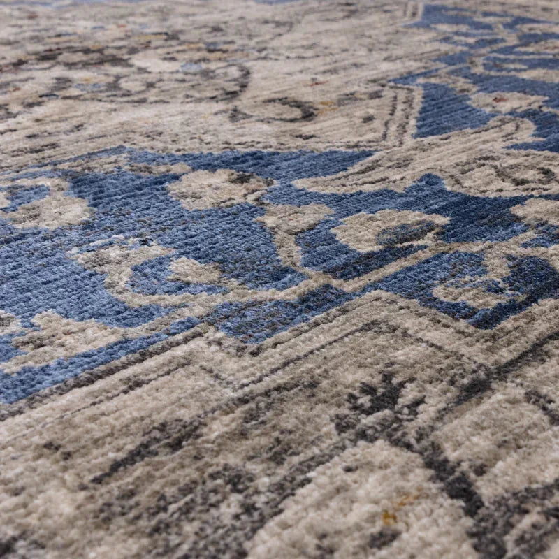 Close up of patterned rug with blue and grey detail and textured pile
