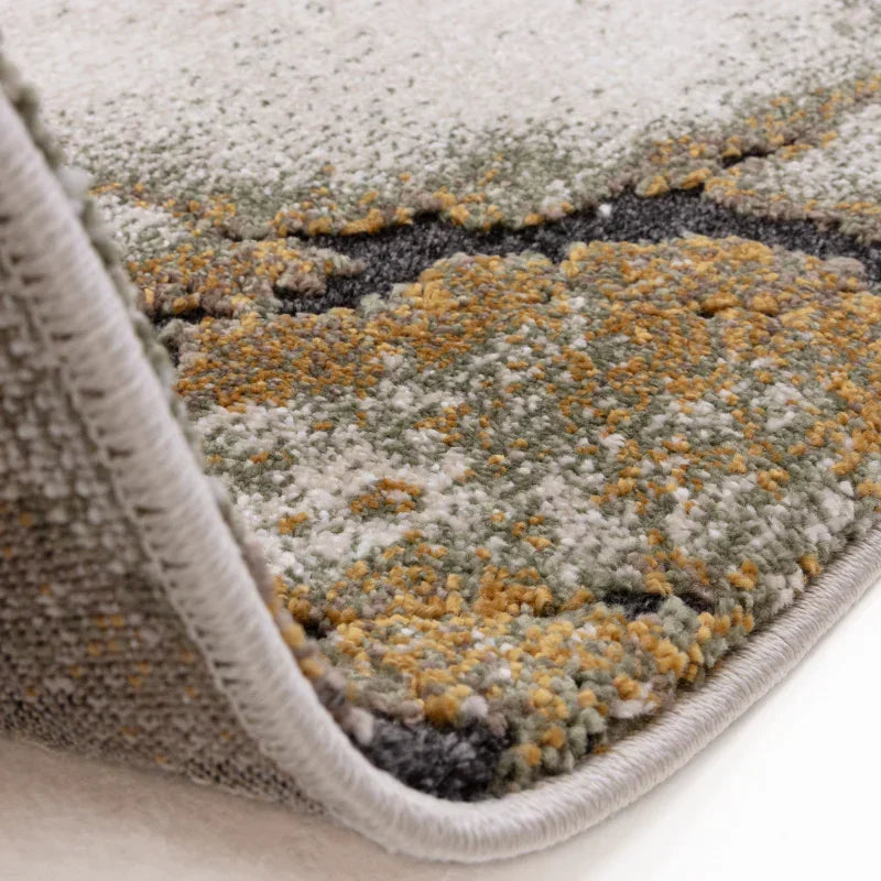 Close-up of modern abstract area rug with textured green, yellow, and grey pile