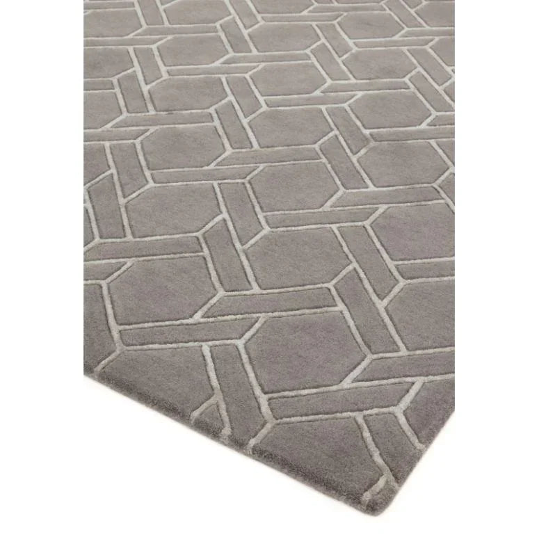 Grey geometric patterned rug with raised textured design, corner angle view