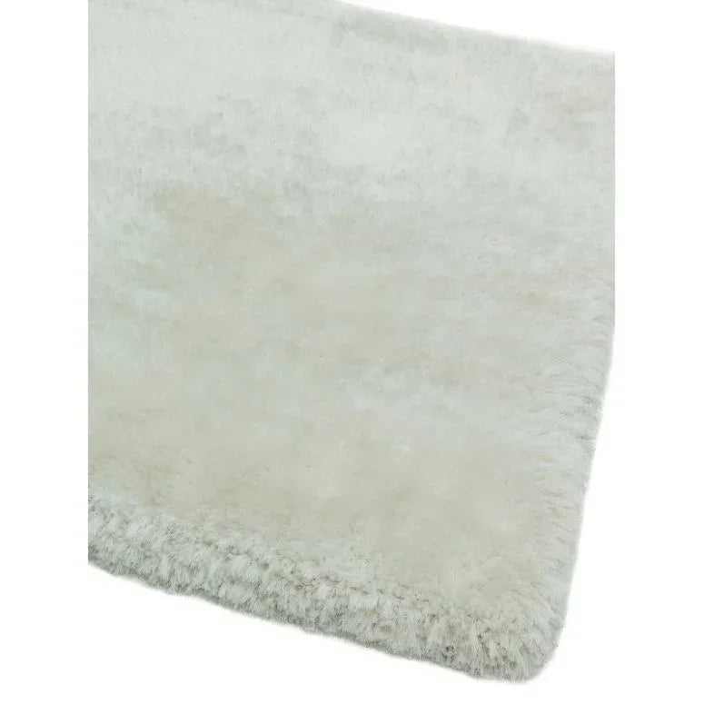 Close view of cream shaggy rug with soft pile and textured edge