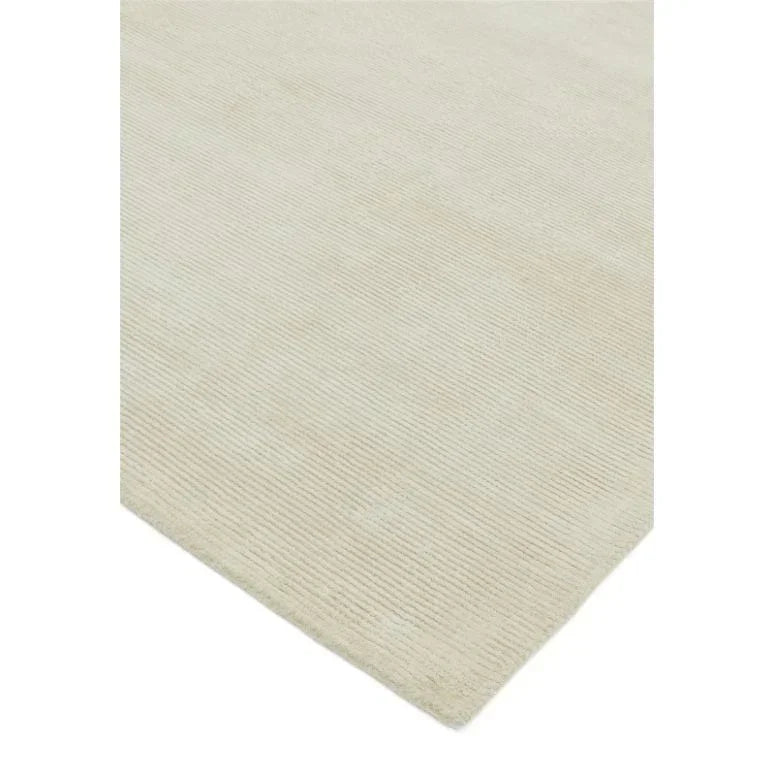 Beige textured area rug with subtle linear pattern and corner view