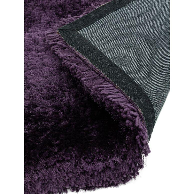 Plum shaggy rug with soft pile and corner showing non-slip backing