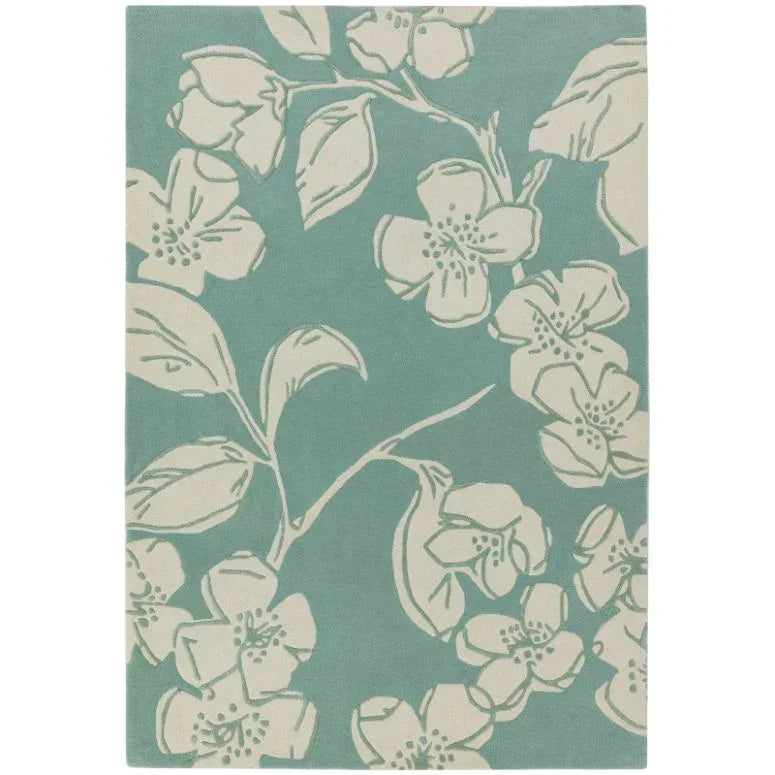 Floral area rug with cream flower pattern on teal background