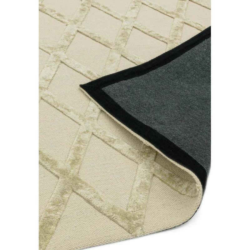 Cream geometric pattern rug with black edge, corner folded to show backing