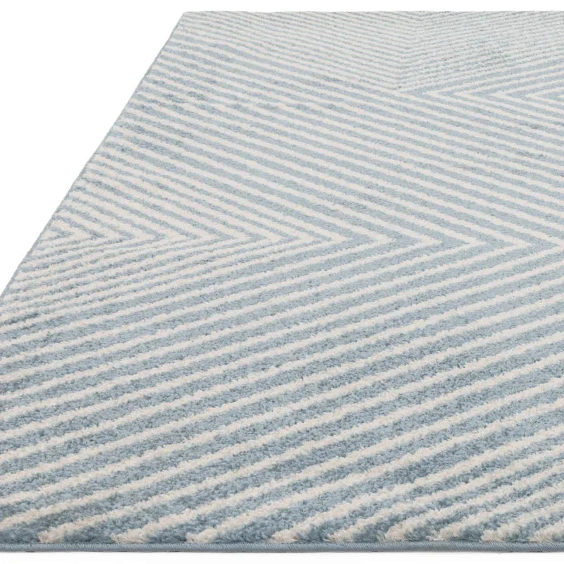 Light blue and white striped rug with chevron pattern, close-up of textured surface