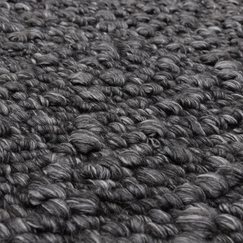 Close up of chunky charcoal wool rug texture with thick handwoven loops