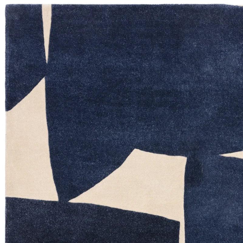 Modern area rug with navy blue and cream abstract geometric pattern