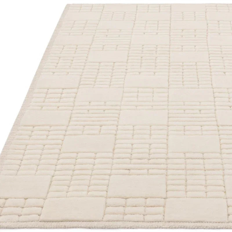 Cream wool rug with raised geometric square pattern, shown from low side angle
