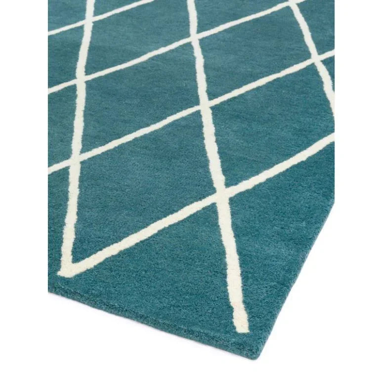 Teal area rug with white crisscross line pattern and angled edge