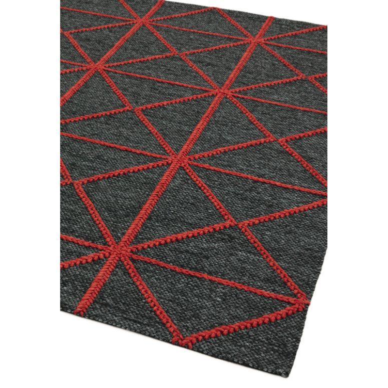 Dark grey area rug with red geometric pattern and textured surface