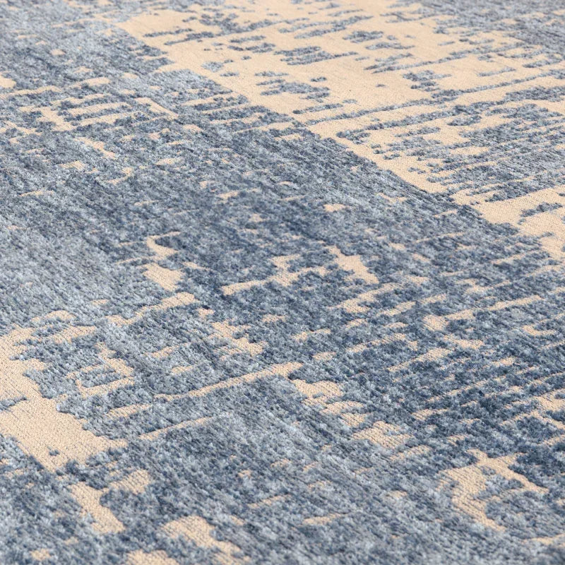 Closeup of blue and beige patterned rug with textured fabric detail