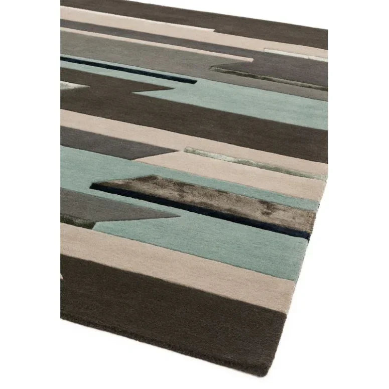 Modern geometric area rug with brown, beige, and teal pattern in close-up view
