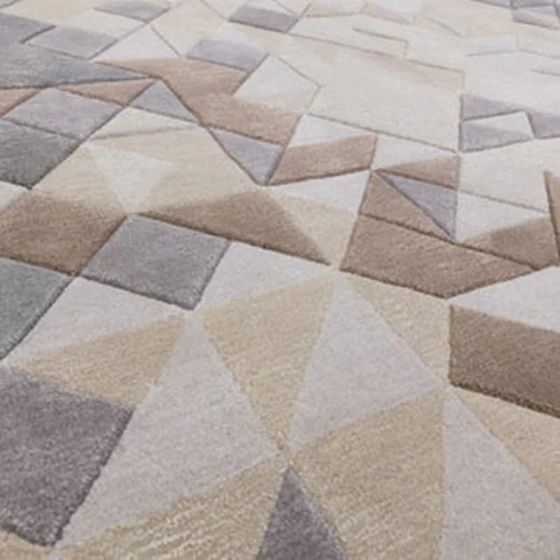 Geometric patterned rug in beige, grey, and taupe tones with textured surface