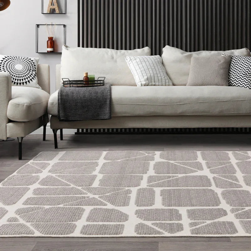 Modern beige sofa with scatter cushions and geometric pattern rug in living room