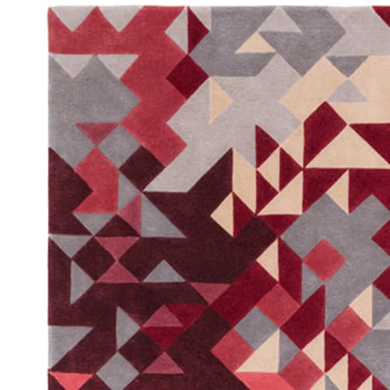 Modern geometric area rug with red, burgundy, grey, and beige triangular pattern