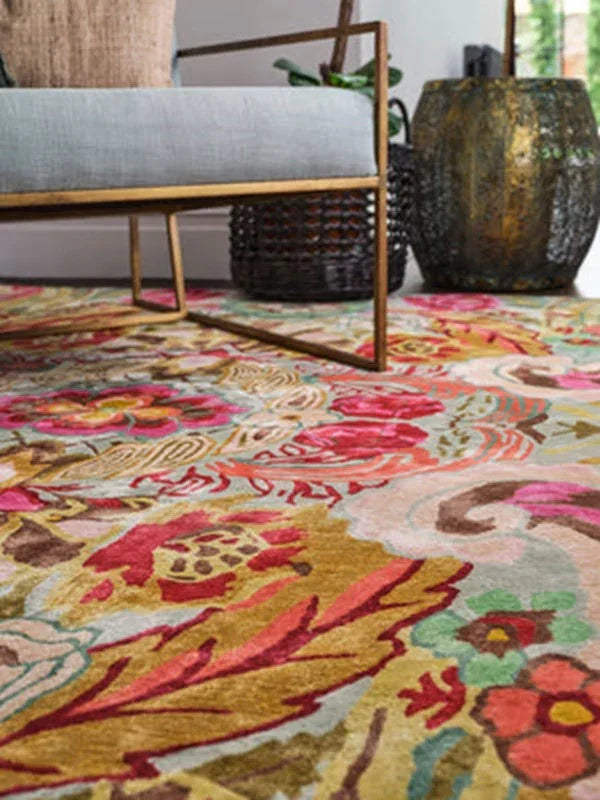 Colorful patterned area rug under modern armchair with metal legs and decorative plant pots