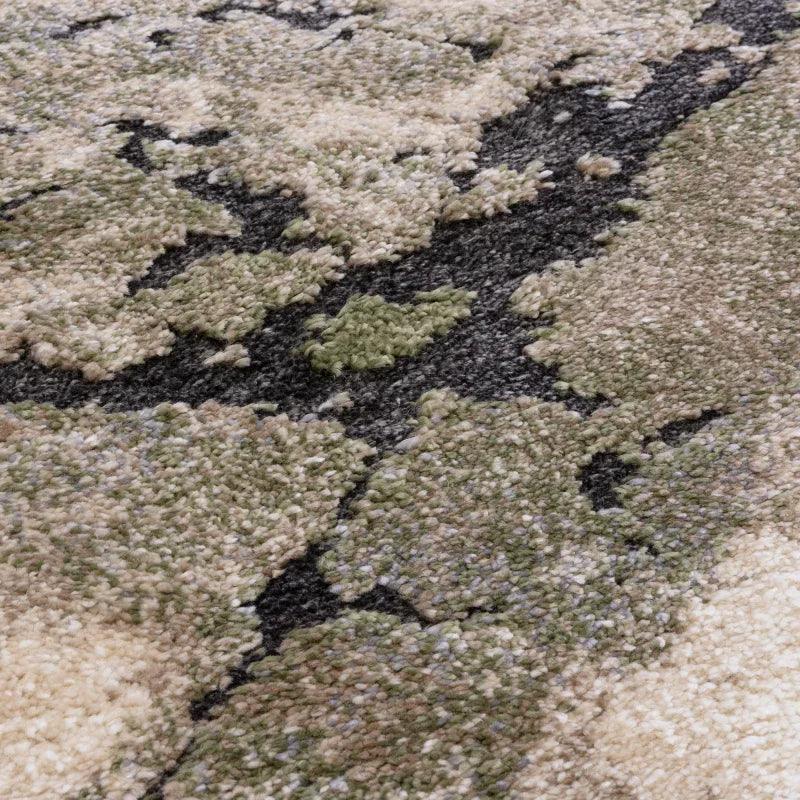 Close view of patterned area rug with green, beige, and black textured pile