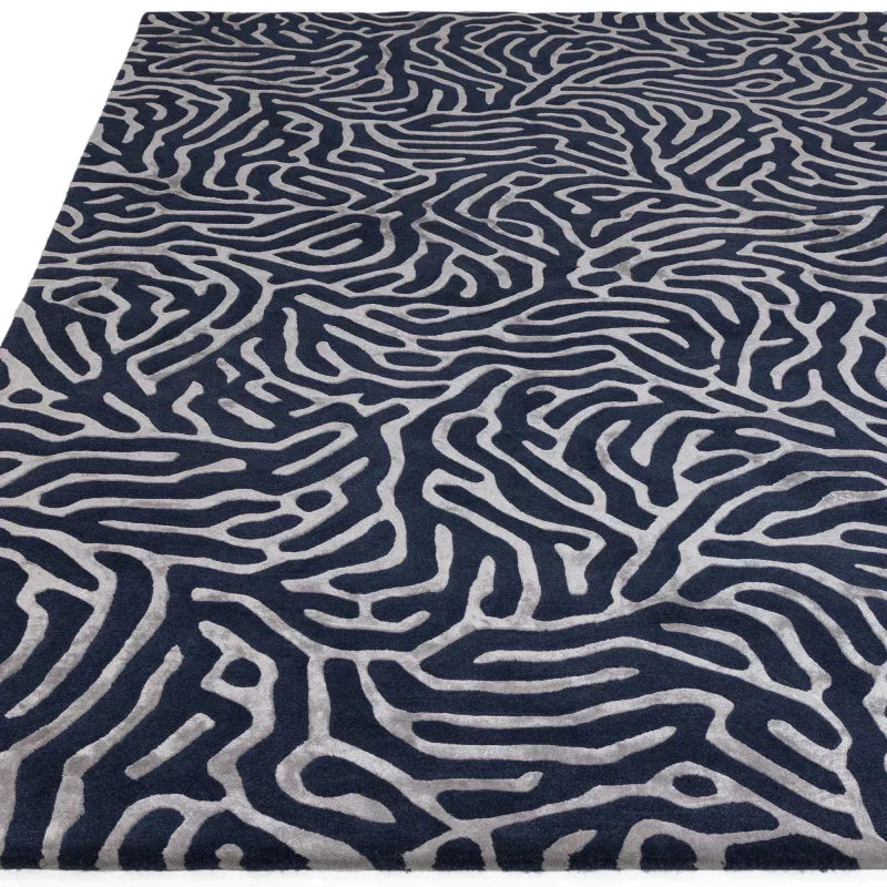 Navy and grey patterned area rug with abstract design on soft textured surface