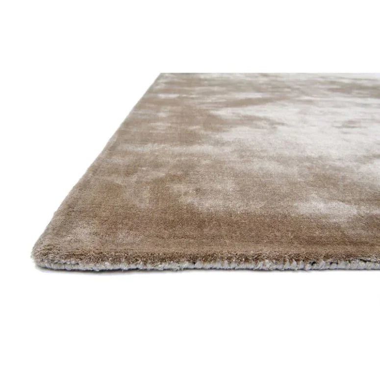 Beige area rug with plush pile and soft texture, shown from a side angle