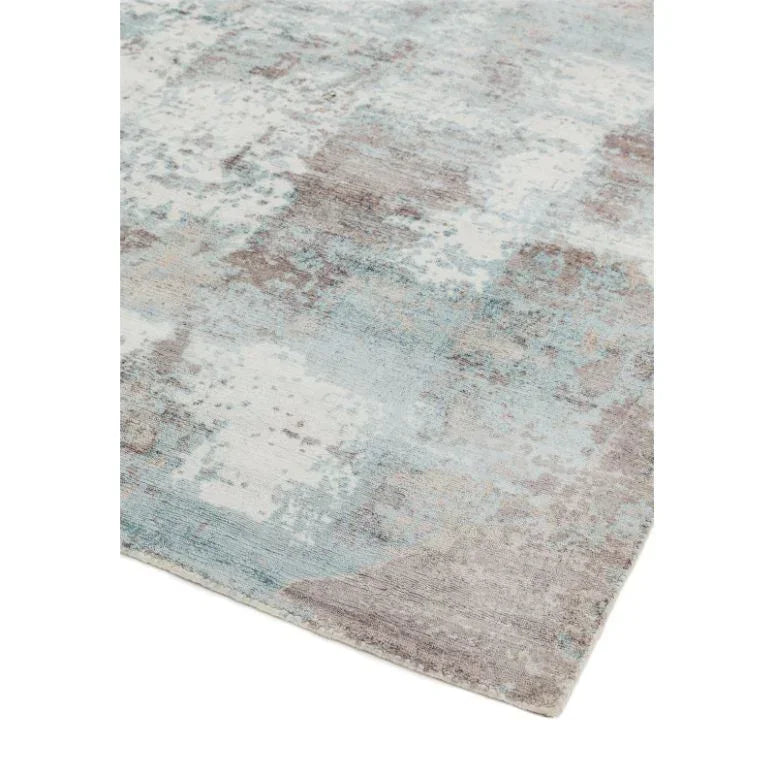 Abstract area rug with blue, grey and cream pattern closeup