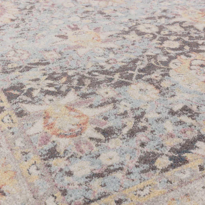 Close up of patterned area rug with soft pastel blue, grey, and cream floral design