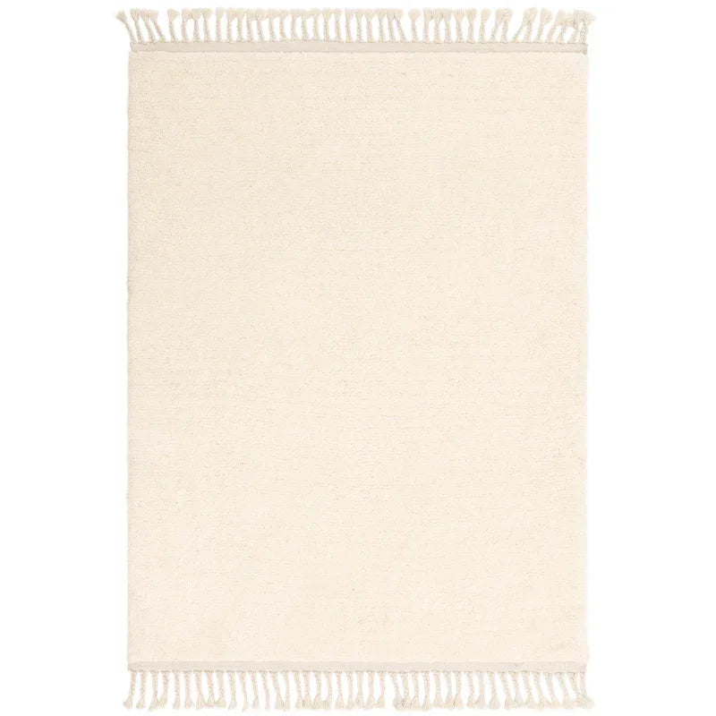 Cream area rug with fringed edges shown from above