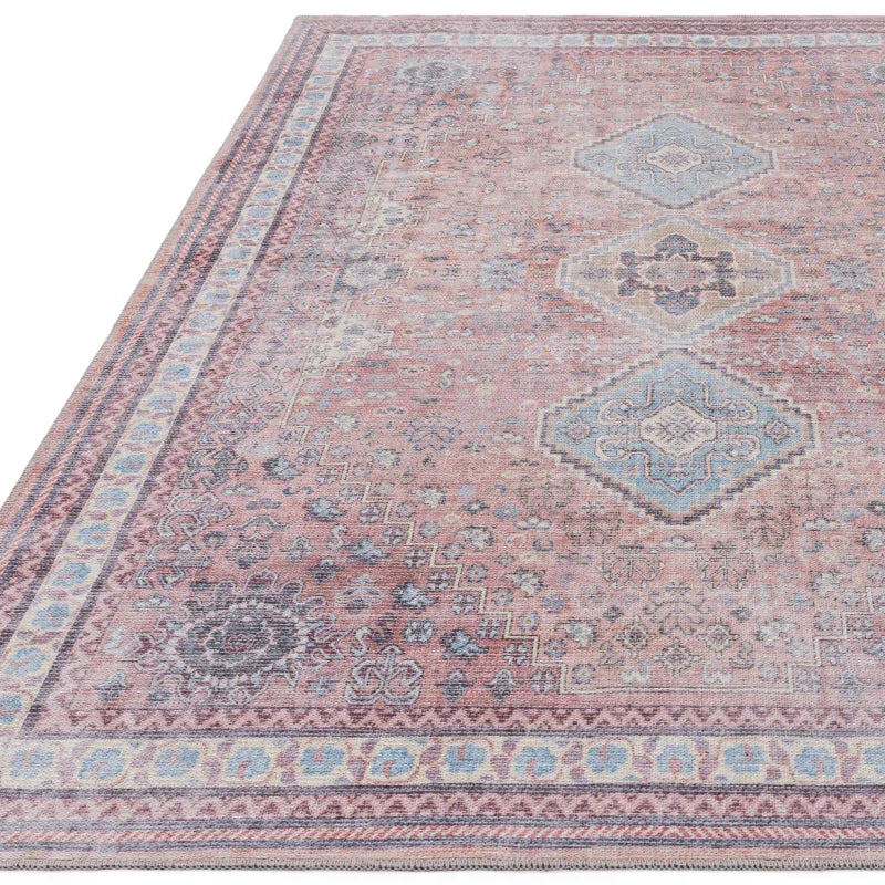 Vintage style area rug with pink and blue geometric and floral patterns