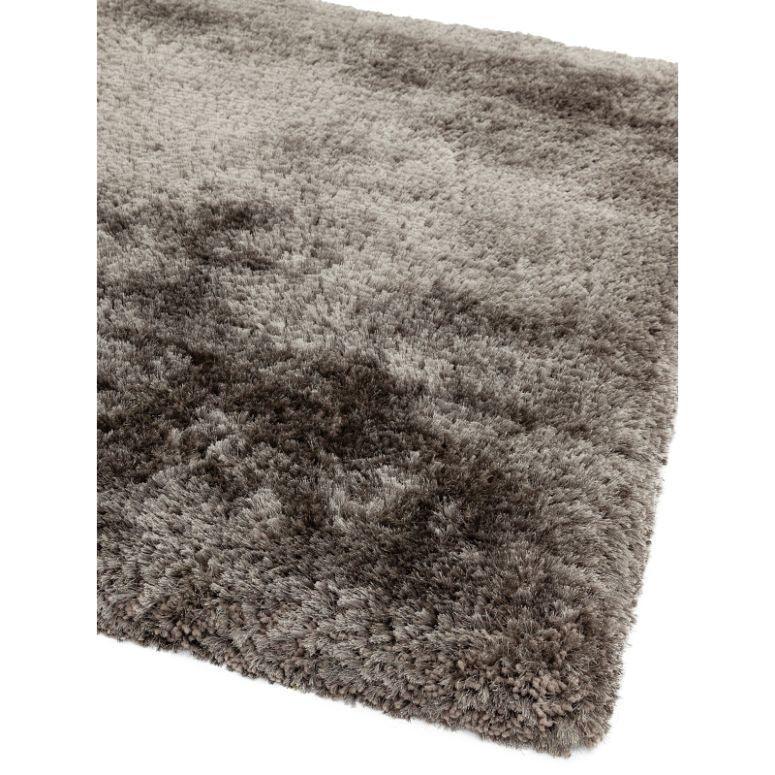 Closeup of grey shaggy rug corner with soft plush pile texture