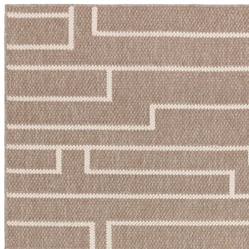 Beige geometric pattern rug with textured woven detail, close-up view