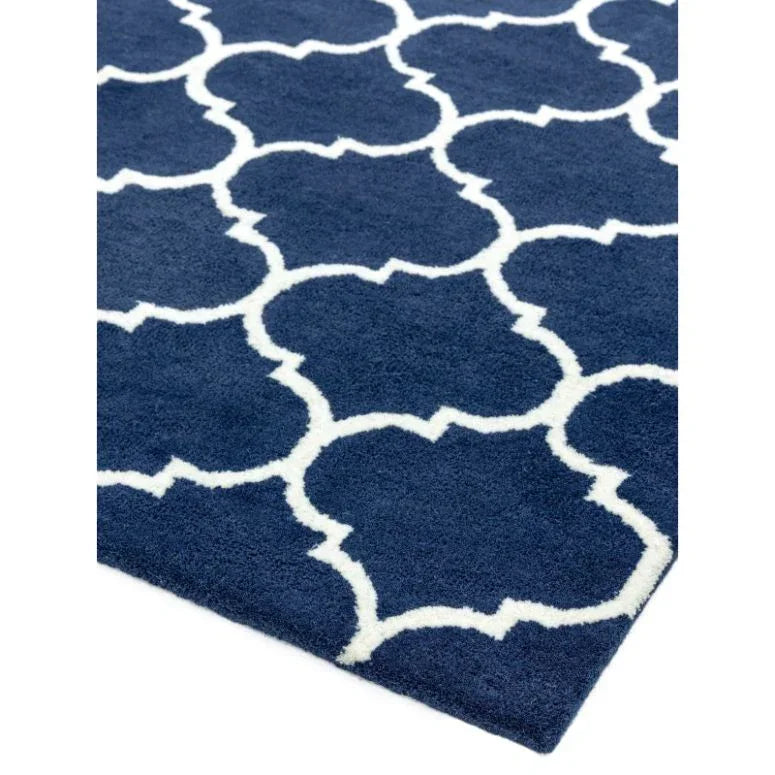 Blue area rug with white geometric lattice pattern and soft texture, corner view