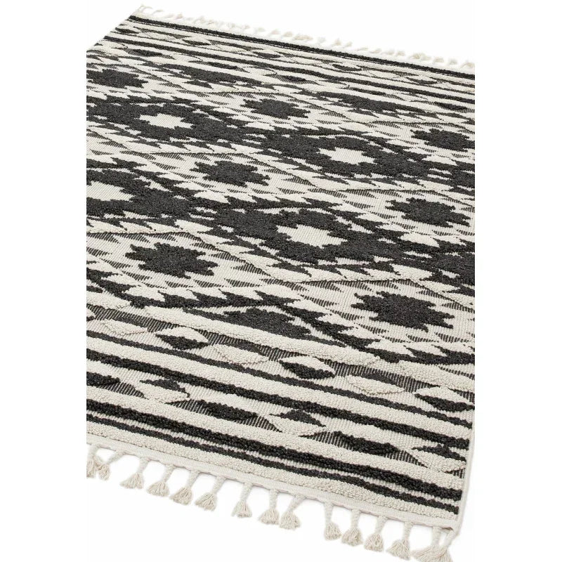 Black and white geometric patterned rug with fringed edges
