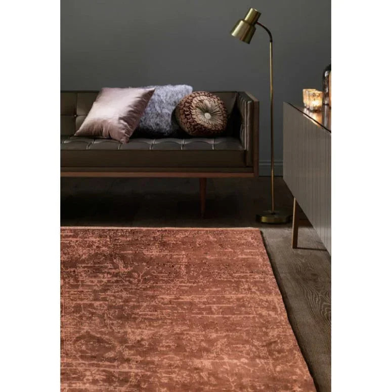 Textured brown area rug on wood floor with sofa, floor lamp, and cushions in living room