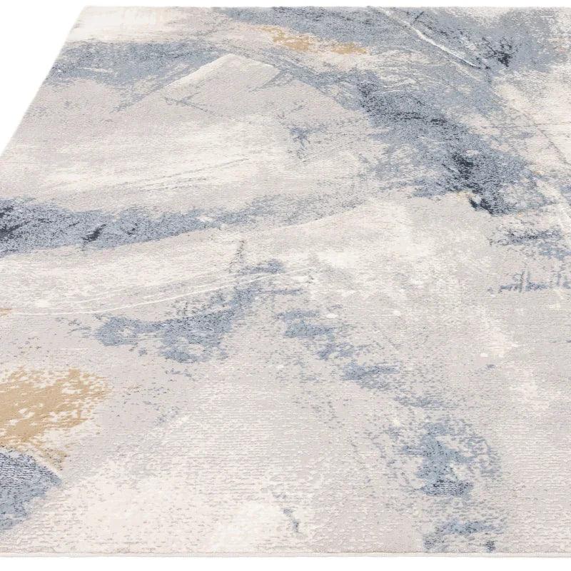 Abstract area rug with blue, beige and grey tones, modern textured design, close angle view