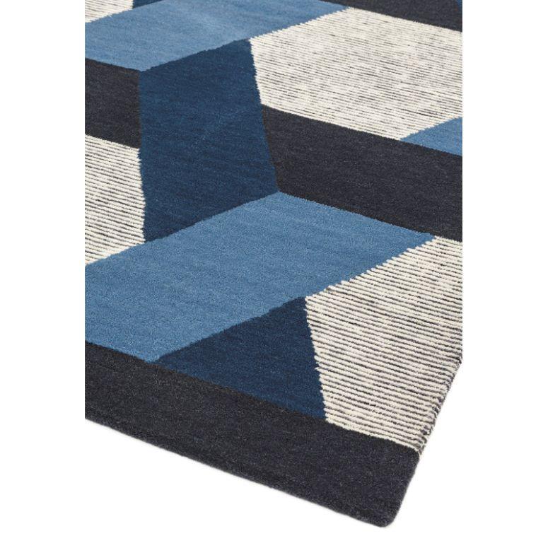 Blue and cream geometric rug corner with bold pattern and textured wool surface
