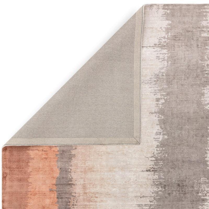 Modern area rug with abstract beige, grey, and terracotta pattern, corner folded back