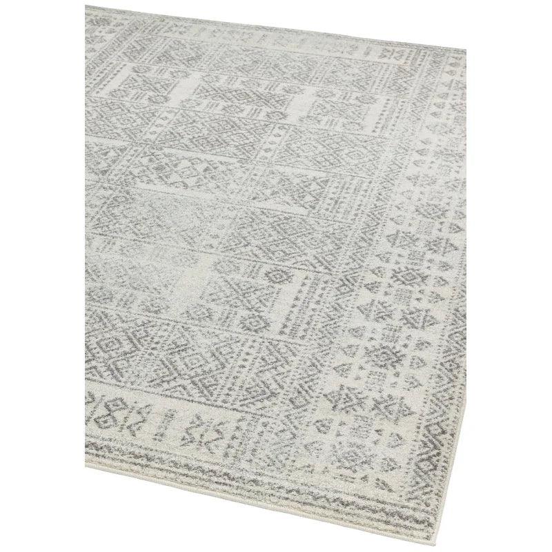Grey patterned area rug with geometric design and textured detail