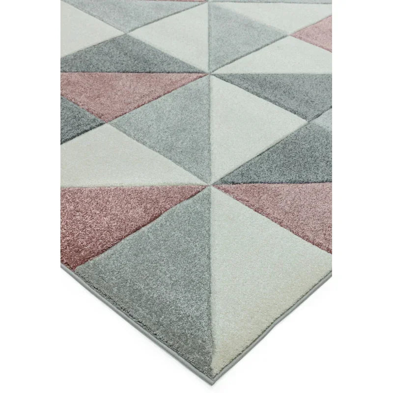 Geometric area rug with grey, white, and blush triangles in a modern pattern