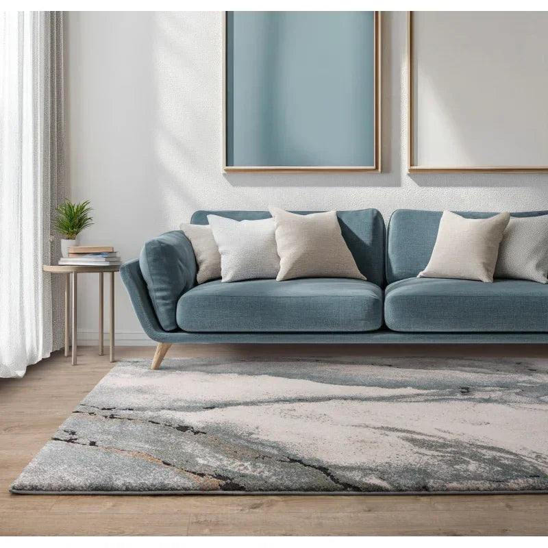 Blue fabric sofa with beige cushions, marble effect rug, and minimalist decor