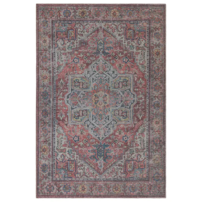 Vintage-style area rug with faded red, blue, and grey ornate pattern and decorative border