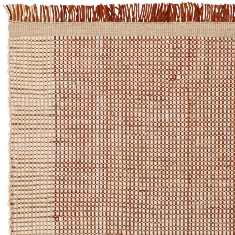 Brown and cream woven area rug with fringe corner detail