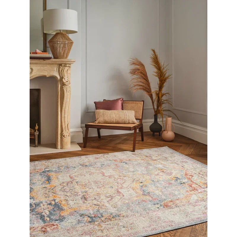 Abstract area rug in pastel colors on wooden floor with accent chair and decorative vases