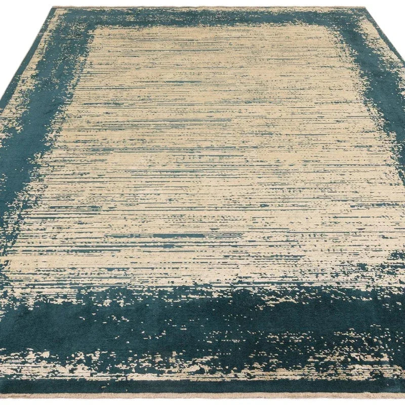 Contemporary area rug with blue border and cream abstract center design