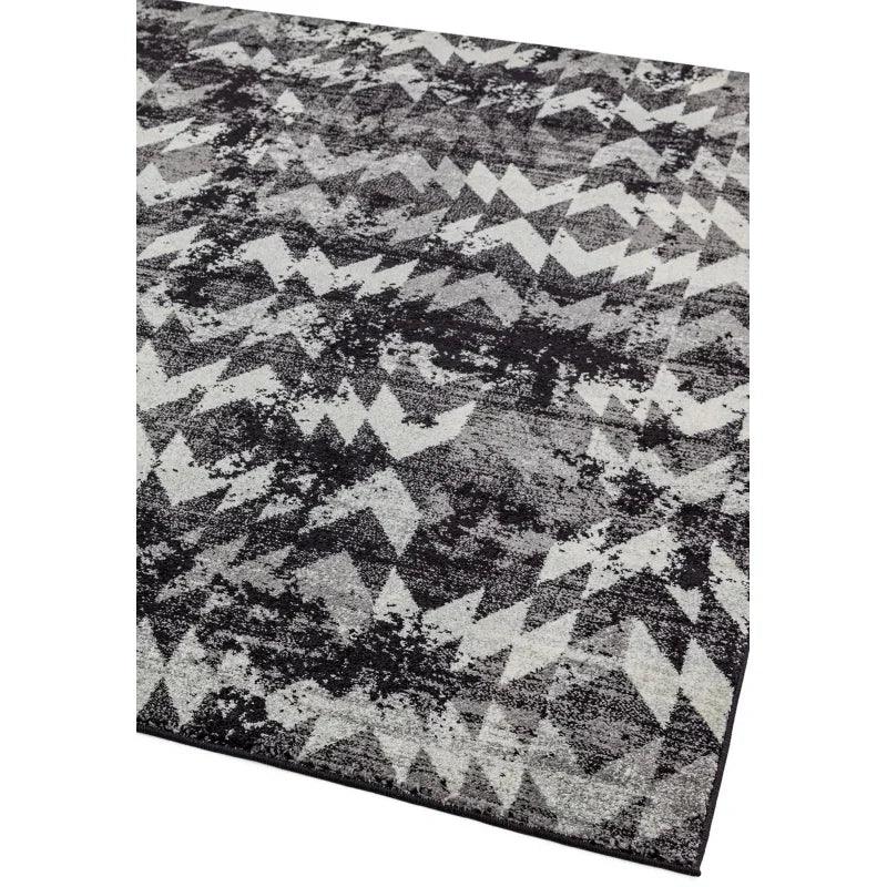 Black and grey area rug with abstract geometric zigzag pattern