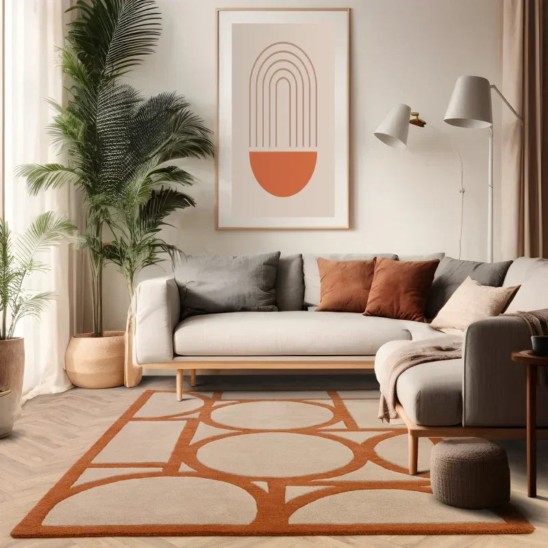 Modern living room with beige sofa, orange accent cushions and geometric area rug
