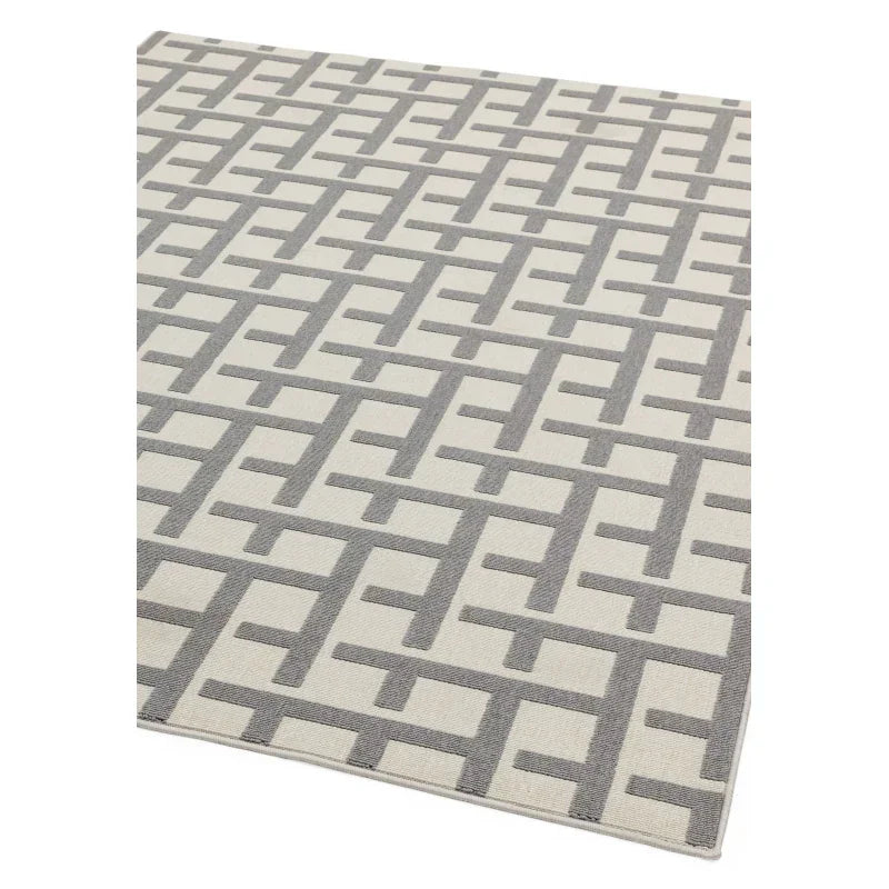 Grey geometric patterned rug with cream background, shown from angled top view