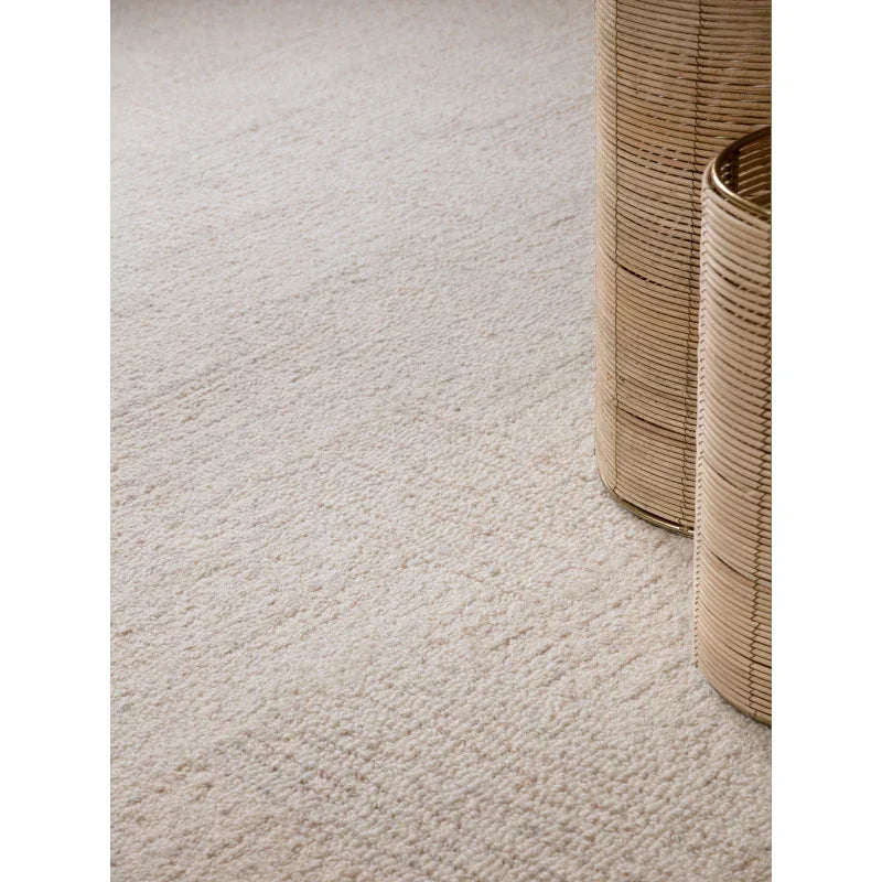 Neutral cream textured carpet with round wicker baskets in living room setting