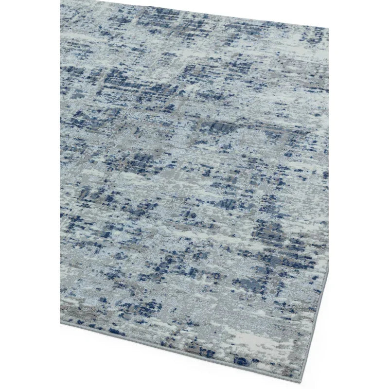 Blue and grey patterned area rug with abstract design, angled corner view