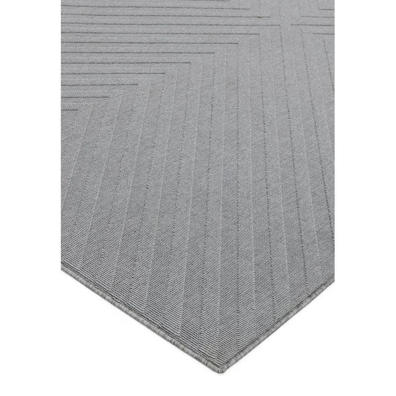 Grey geometric pattern rug with angled corner and subtle textured lines