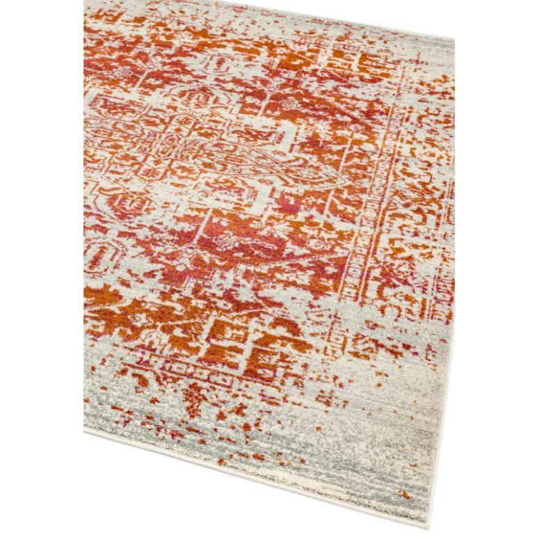 Red and orange patterned area rug with faded vintage design on a light background